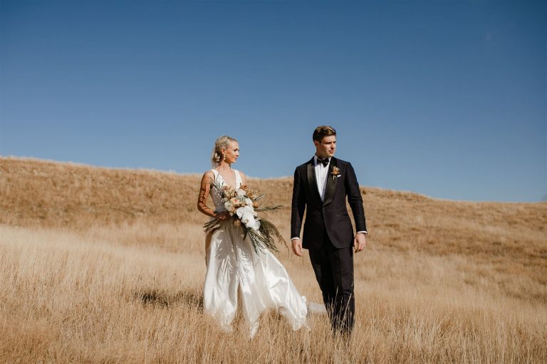 Bride and groom lovingly walking in the mountain of Appleby House at Nelson Ana Galloway Photography