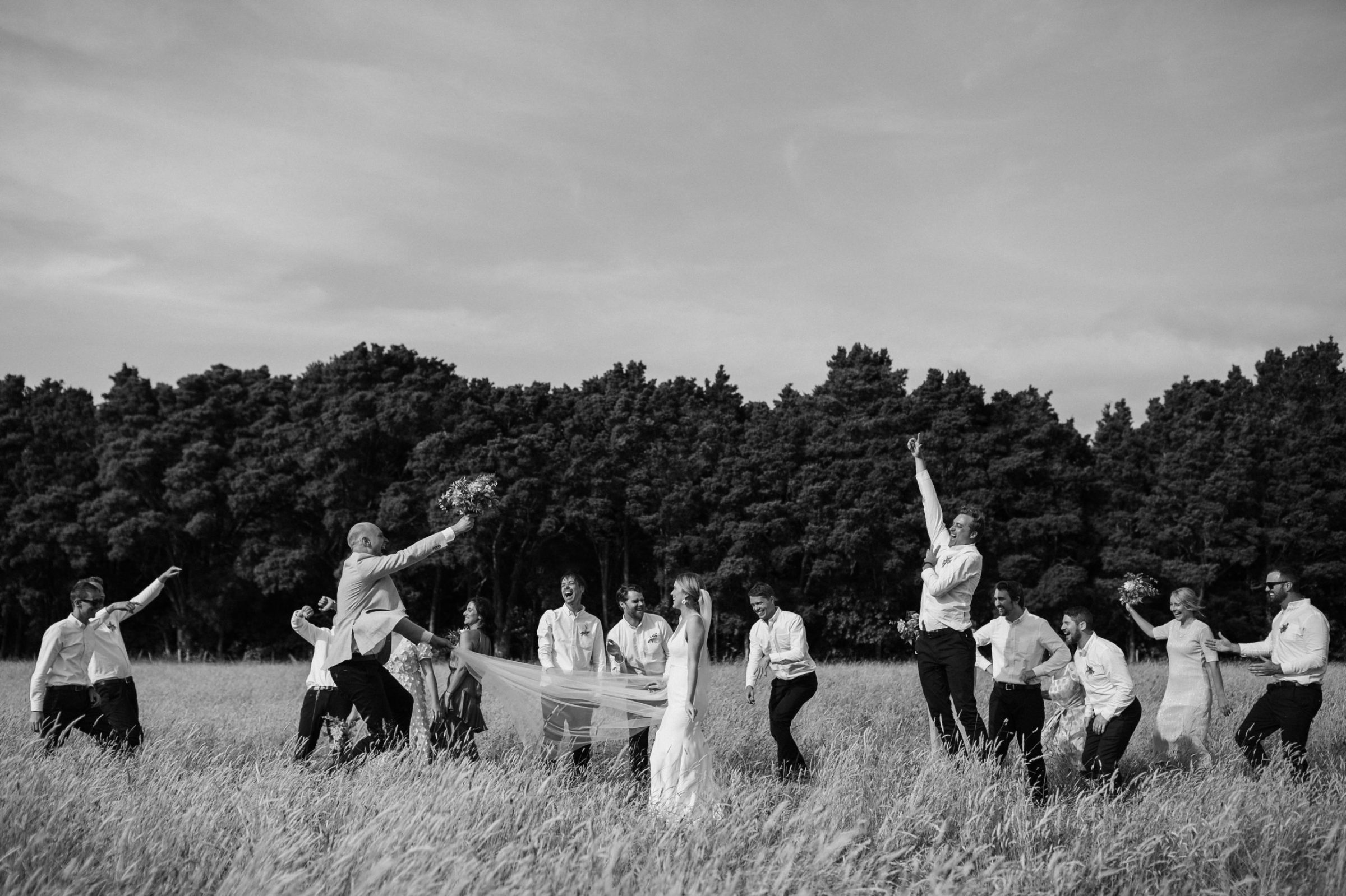 Bridal party dancing in a field of summer grass Martinborough Wedding Ana Galloway Photography