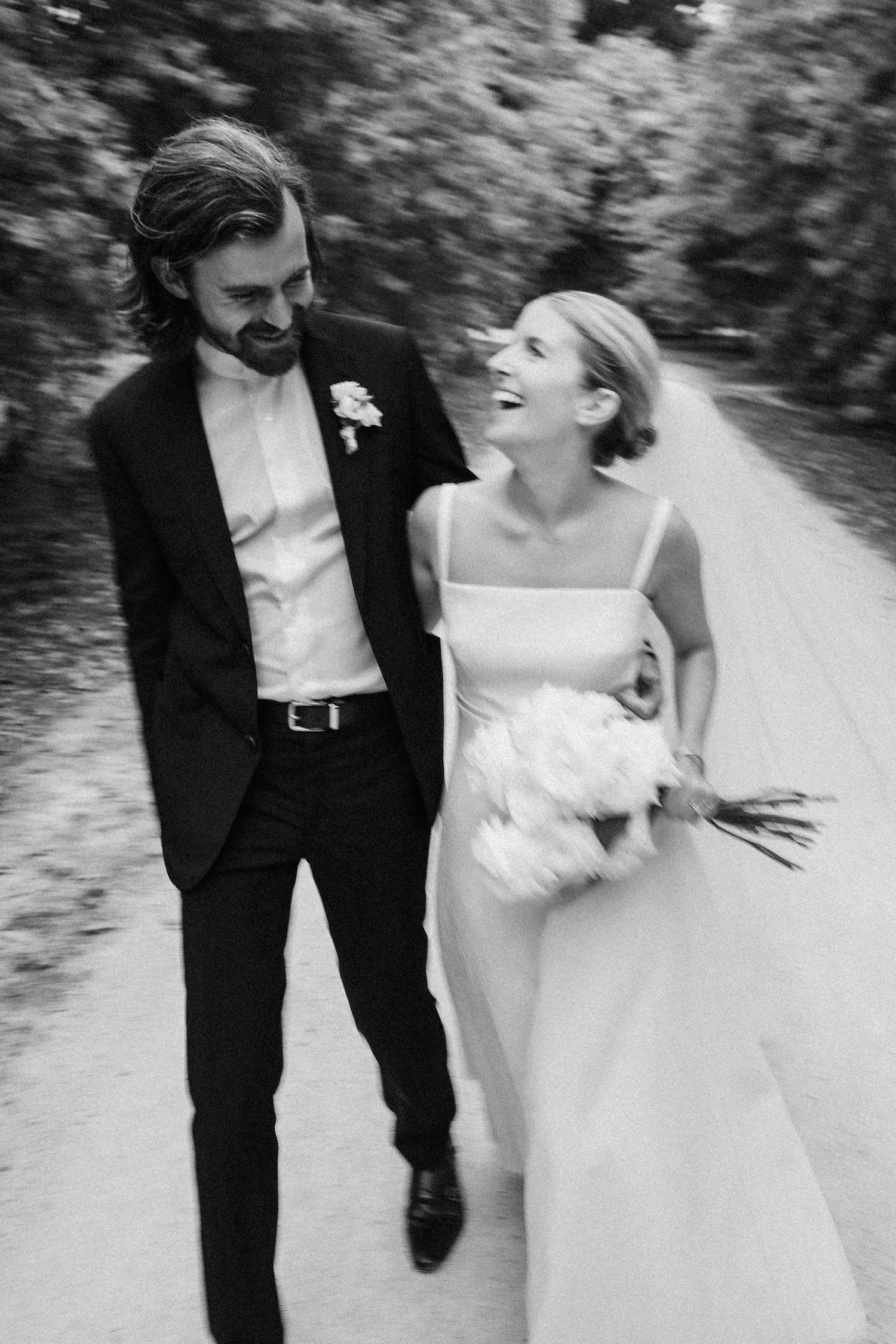 Editorial shot of bride and groom candidly walking down the road smiling and laughing at each other Hawkes Bay Wedding Ana Galloway Photography