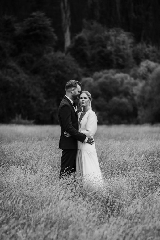 Modern Classic Bride and groom in long golden summer grass New Zealand Elopement