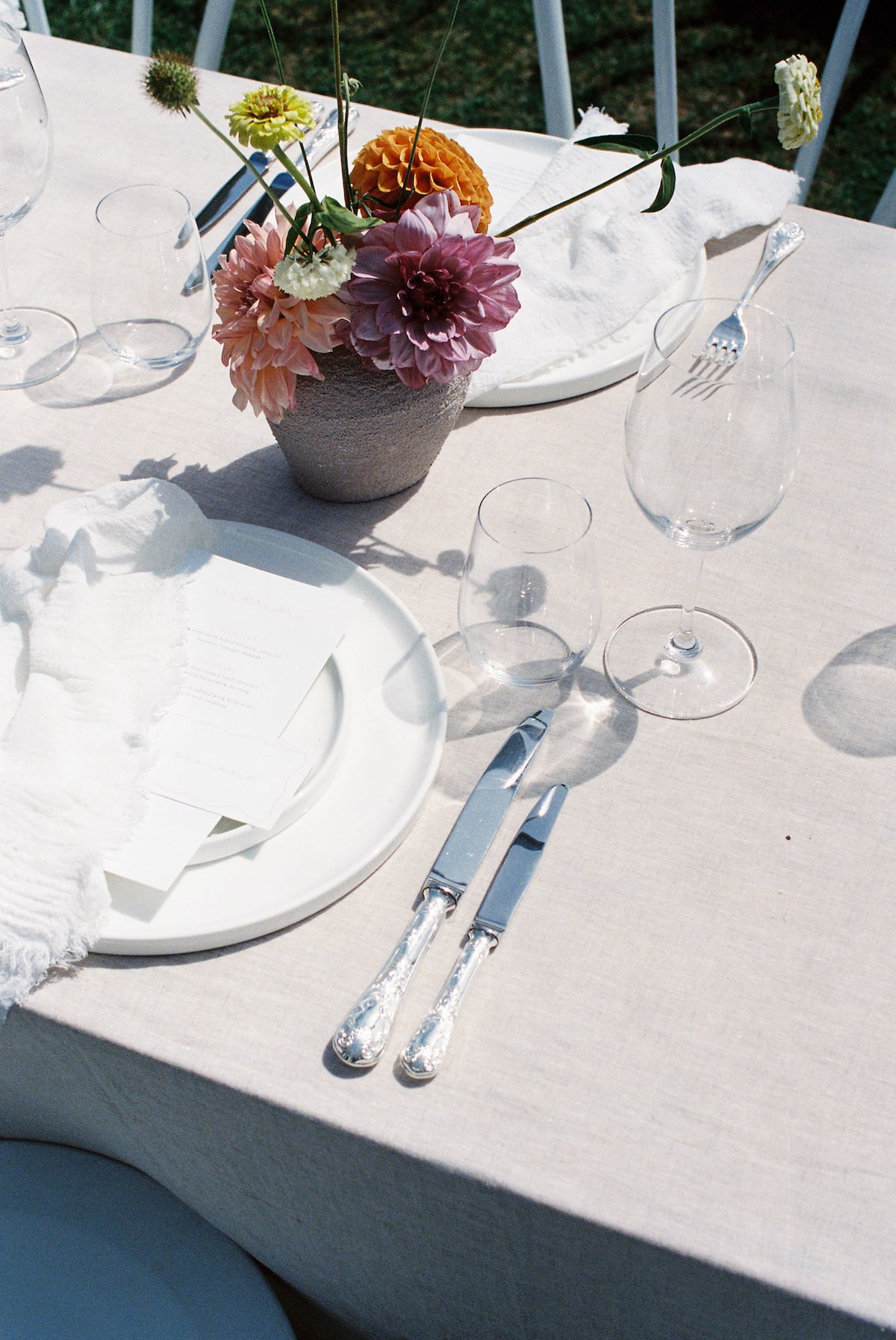 wedding reception simple yet elegant table setting with beautiful bright flower arrangement. Ana Galloway Photography