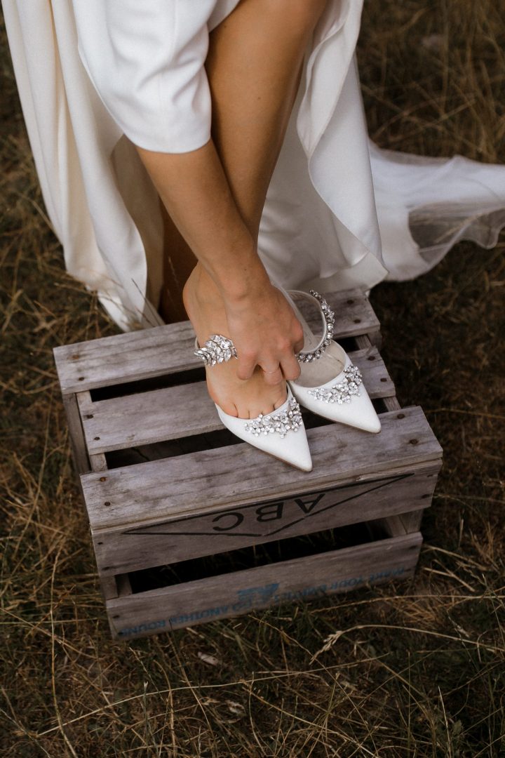 Bride putting on her diamante studded Manolo Blahnik shoes during her Nelson wedding Ana Galloway Photography