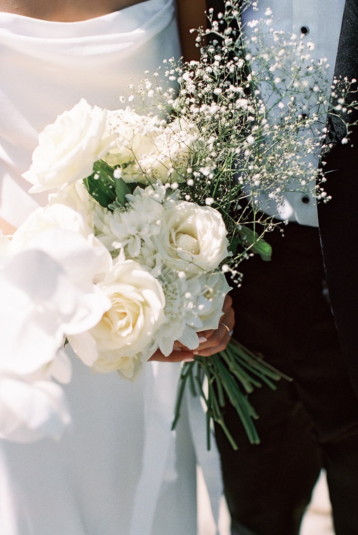 bride and groom walking side by side while holding bride's bouquet film photo Ana Galloway Photography