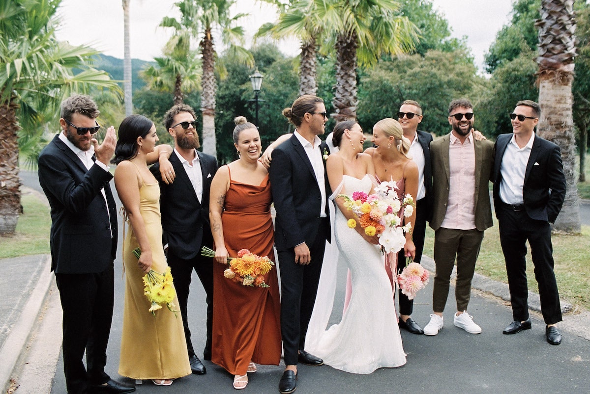 A fun photo capturing the couple and their wedding party, with laughter and joy radiating through the frame.