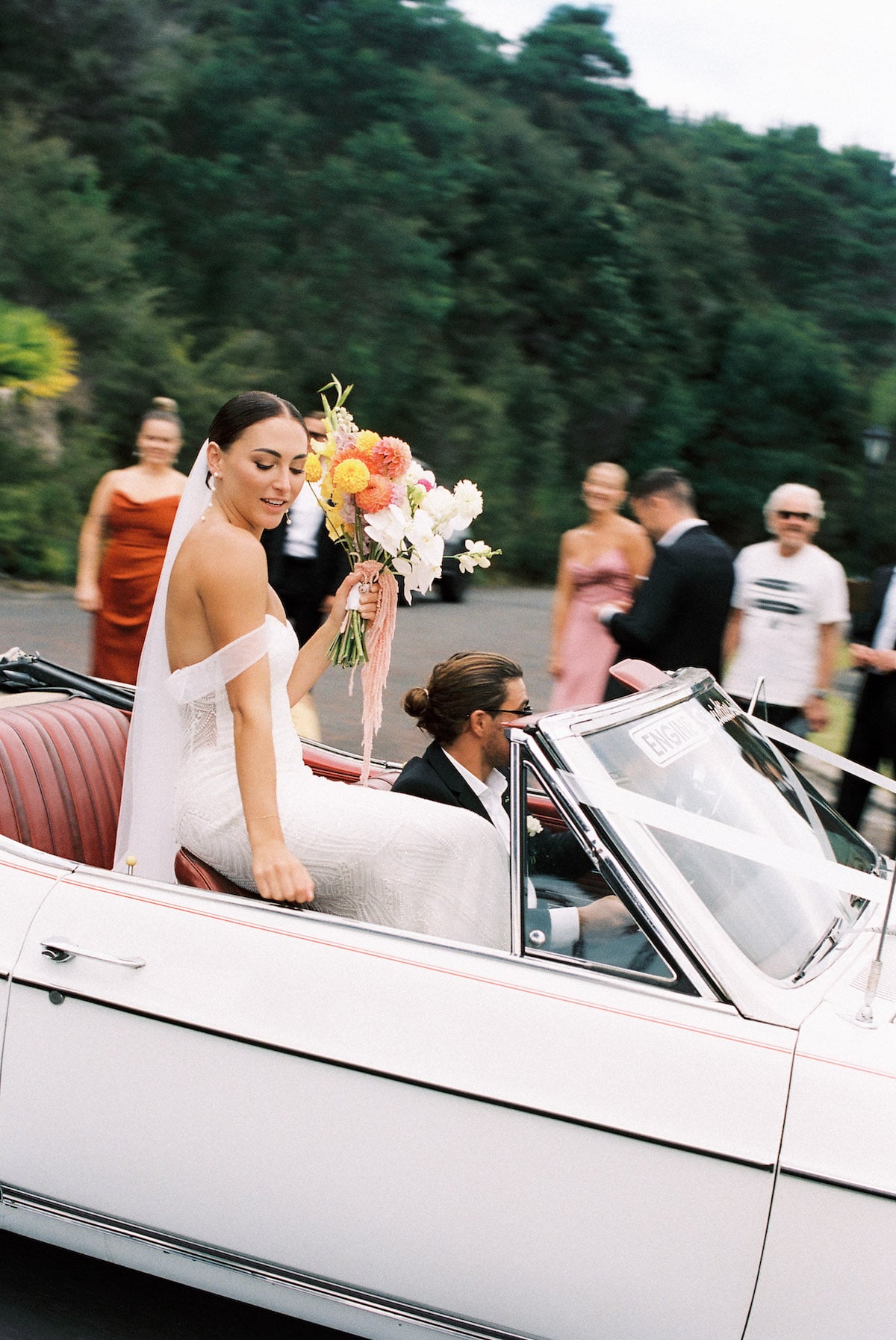 bride ans groom riding in their wedding car with their bridesmaids and groosmen film photo Ana Galloway Photography