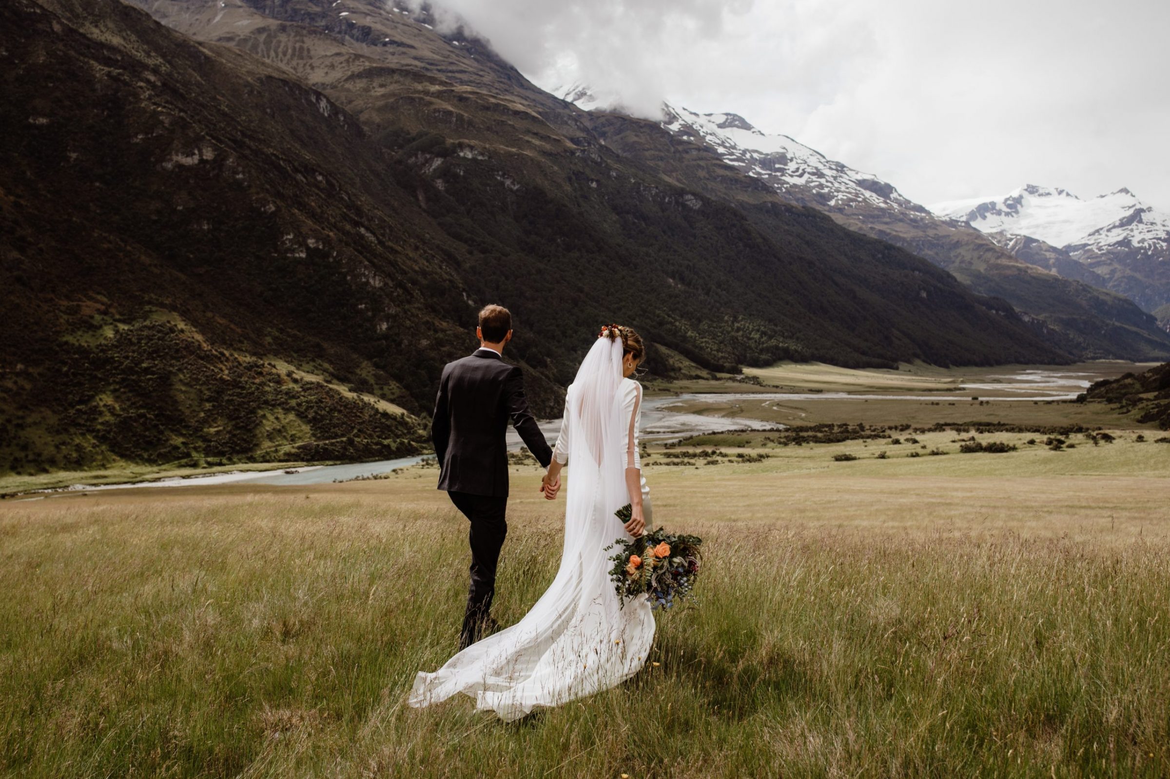 Bride and Groom during adventurous elopement looking out to the view at the top of a mountain in Queenstown New Zealand