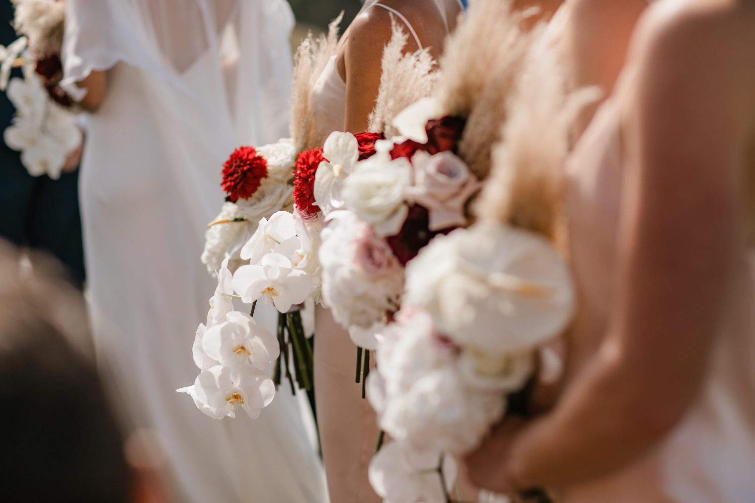 White orchid and red rose bouquets at modern wedding at Kauri Bay Boom rock Wedding New Zealand