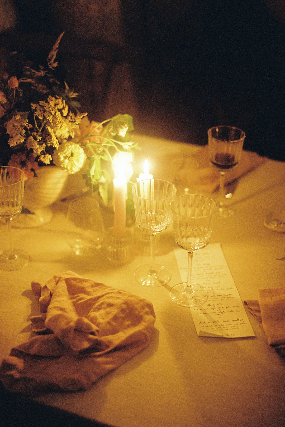 wedding reception table setting detail with florals and candles radiating through the film photo Ana Galloway Photography