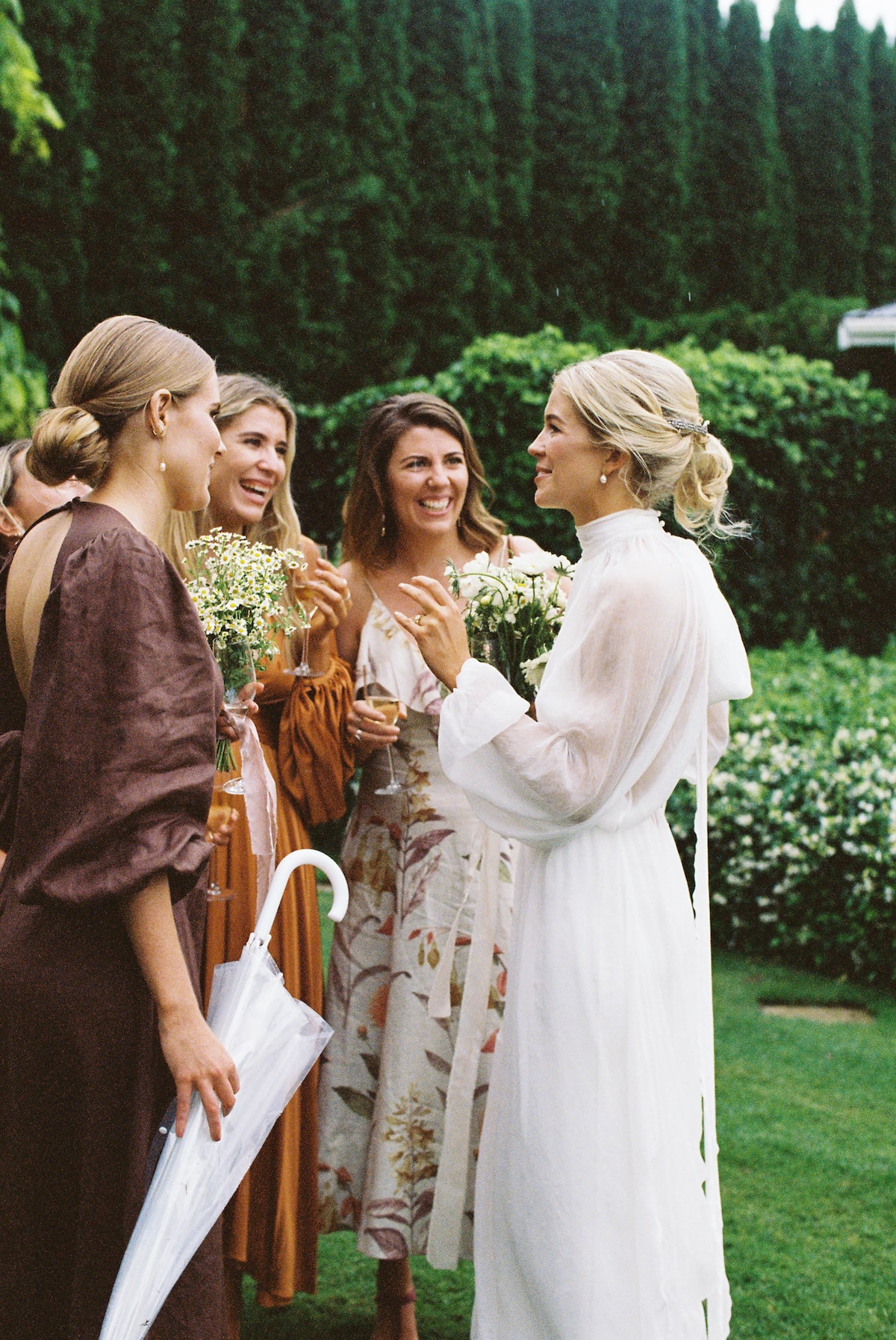 The bride and her bridesmaids share a candid moment, laughing and chatting as they get ready for the wedding ceremony Film photo Ana Galloway photography